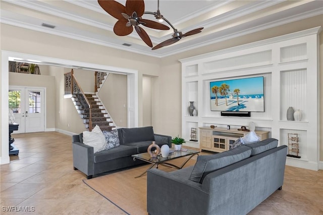 tiled living room with ceiling fan, a raised ceiling, crown molding, and french doors