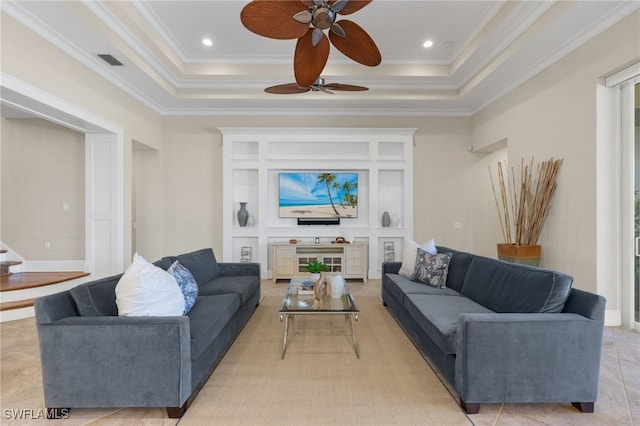 tiled living room featuring a tray ceiling, ceiling fan, and ornamental molding