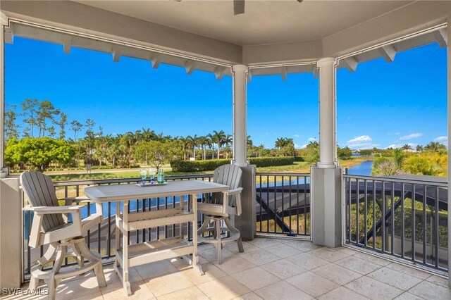 view of patio featuring a balcony and a water view