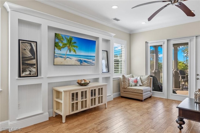 sitting room with crown molding and wood-type flooring