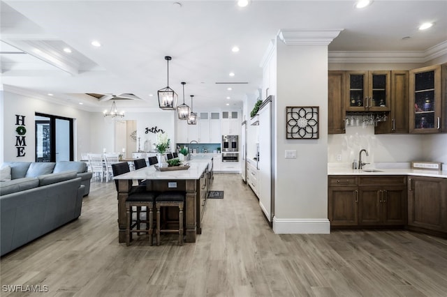 dining area featuring a chandelier, recessed lighting, crown molding, light wood-type flooring, and baseboards