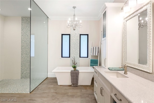 full bath with a chandelier, a soaking tub, ornamental molding, vanity, and wood finished floors