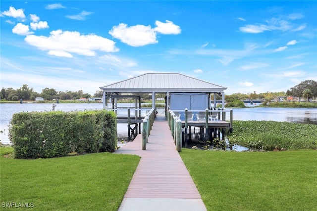dock area with boat lift, a yard, and a water view