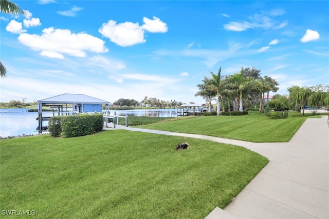 view of community with a water view, a yard, boat lift, and a dock