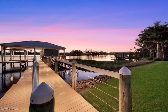 dock area with a water view and a yard