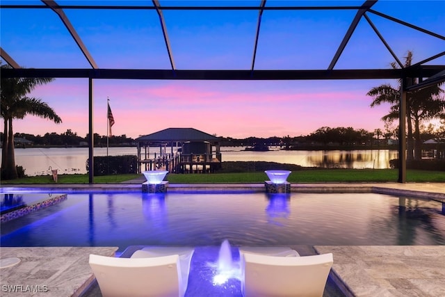 pool at dusk featuring a gazebo, a lanai, and a water view