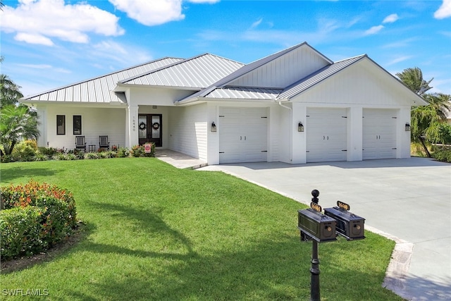 modern farmhouse with a garage, a standing seam roof, french doors, concrete driveway, and a front lawn