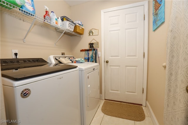 laundry area featuring washer and dryer and light tile patterned floors