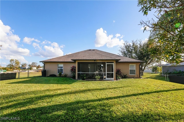 back of property with a lawn and a sunroom