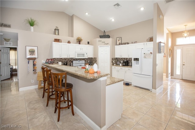 kitchen featuring kitchen peninsula, white appliances, backsplash, white cabinetry, and high vaulted ceiling