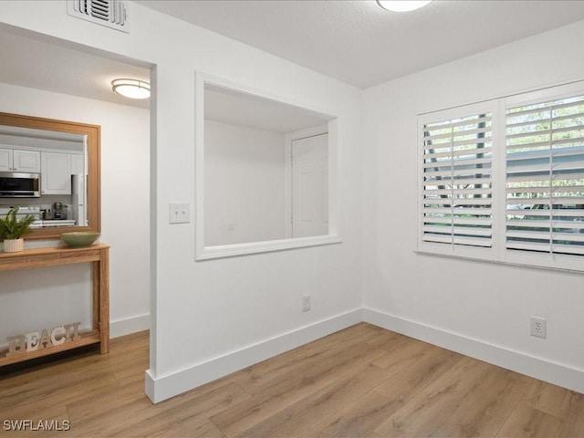 spare room with light hardwood / wood-style flooring