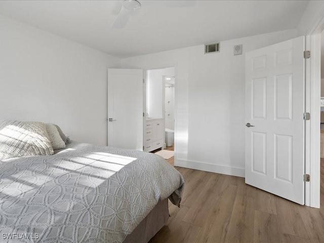 bedroom featuring ceiling fan, ensuite bathroom, and hardwood / wood-style flooring