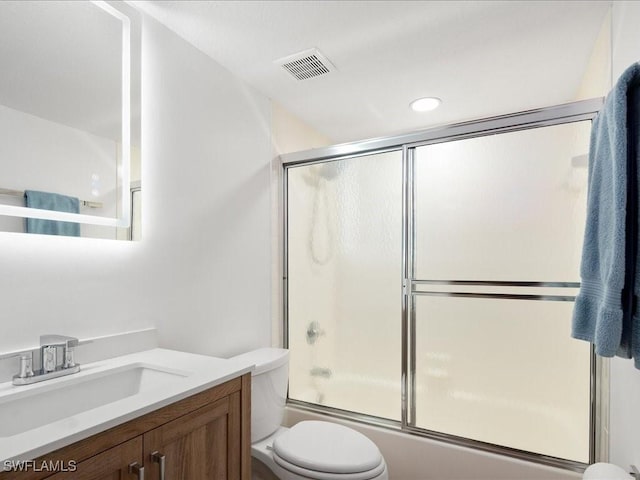 full bathroom featuring shower / bath combination with glass door, vanity, and toilet