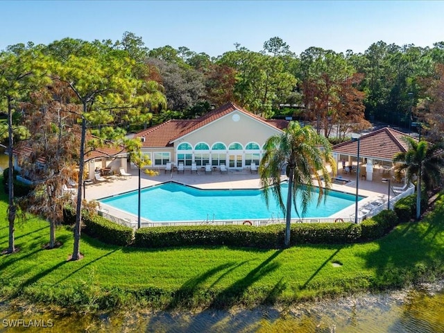 view of pool featuring a patio area, a yard, and a water view