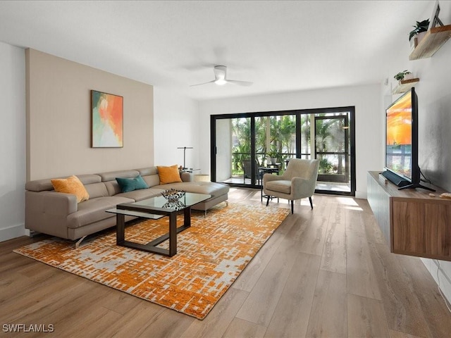 living room with ceiling fan and light hardwood / wood-style floors