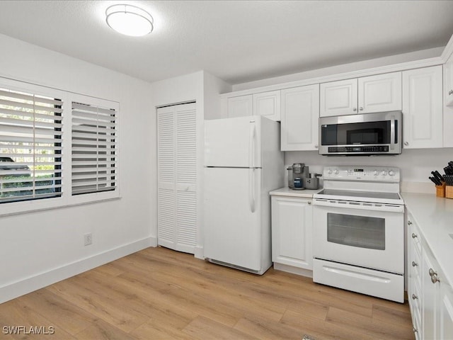 kitchen with light hardwood / wood-style flooring, white cabinets, and white appliances