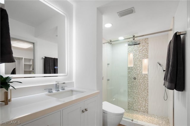 bathroom featuring vanity, toilet, and an enclosed shower