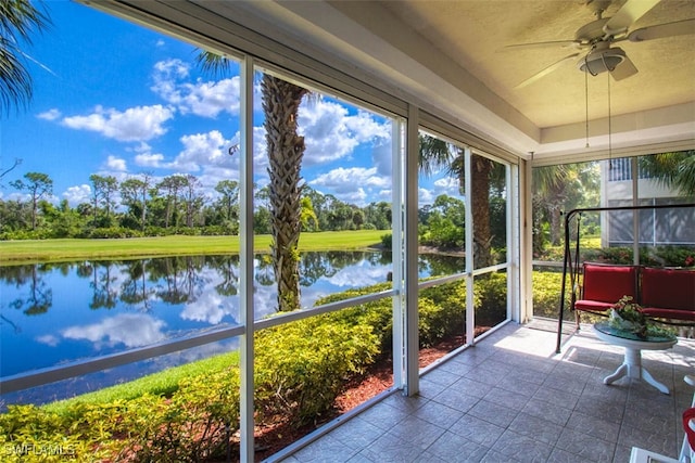 unfurnished sunroom with a water view and ceiling fan