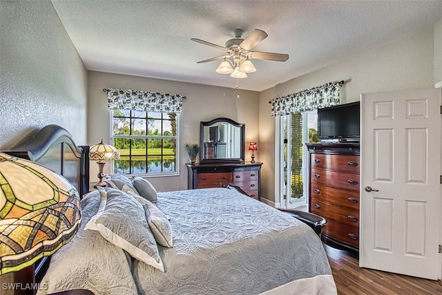 bedroom featuring access to outside, a textured ceiling, dark wood-type flooring, and ceiling fan