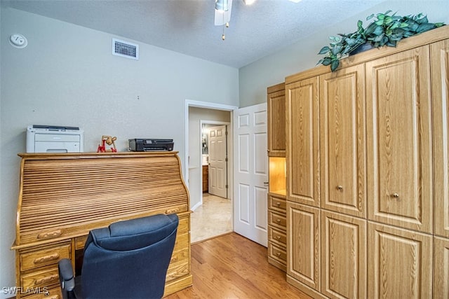 office with a textured ceiling, light hardwood / wood-style floors, and ceiling fan