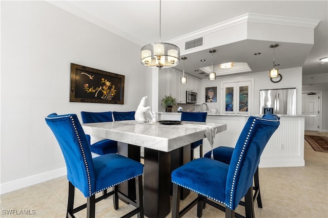 tiled dining room featuring sink, crown molding, and a notable chandelier