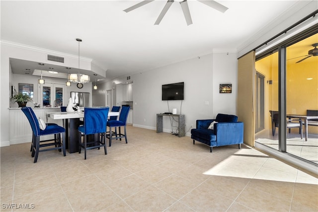 dining space with ceiling fan with notable chandelier, light tile patterned flooring, and ornamental molding