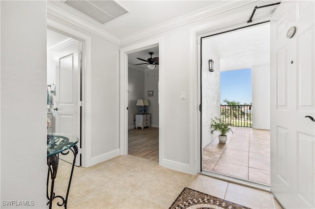 interior space with tile patterned floors, ceiling fan, and crown molding