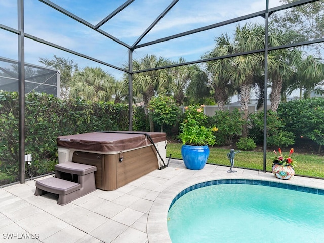 view of swimming pool featuring a hot tub, a patio, and a lanai