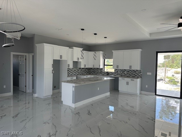 kitchen featuring white cabinetry, a wealth of natural light, and a kitchen island