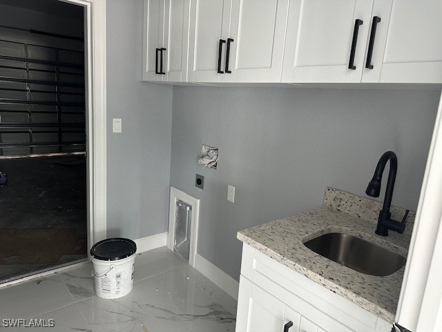 laundry room featuring hookup for an electric dryer, sink, and cabinets