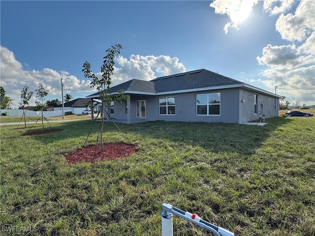 back of property with a lawn