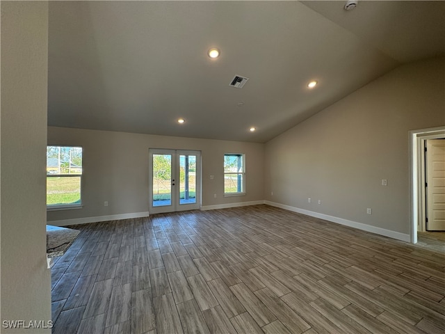 unfurnished room featuring french doors, hardwood / wood-style floors, and vaulted ceiling