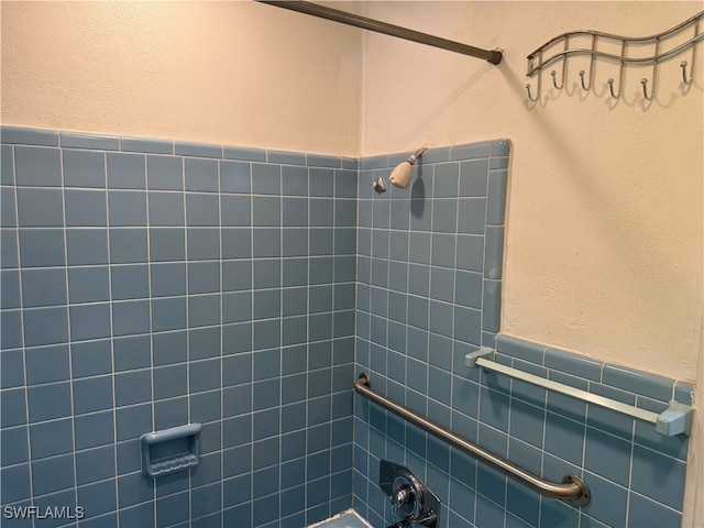 bathroom with tiled shower / bath and tile walls