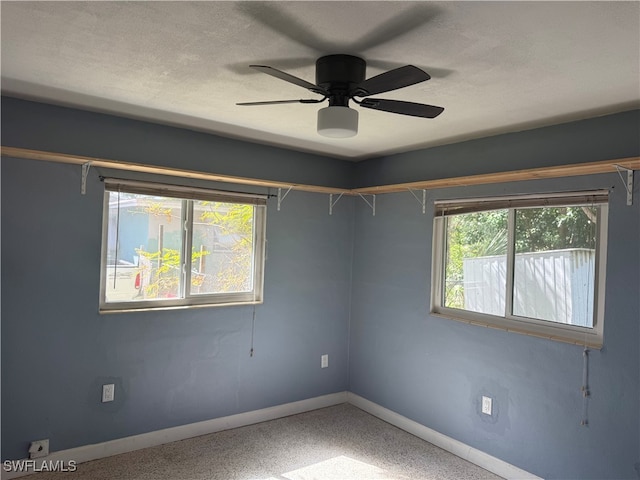 unfurnished room with plenty of natural light, ceiling fan, and a textured ceiling