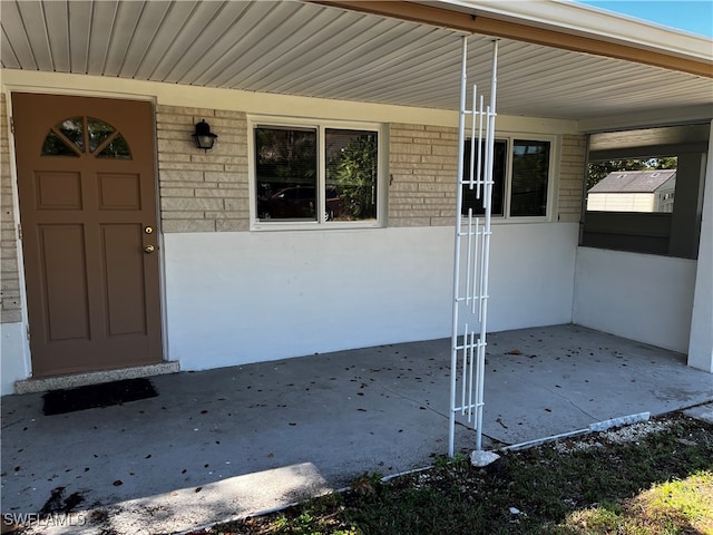 view of exterior entry featuring covered porch