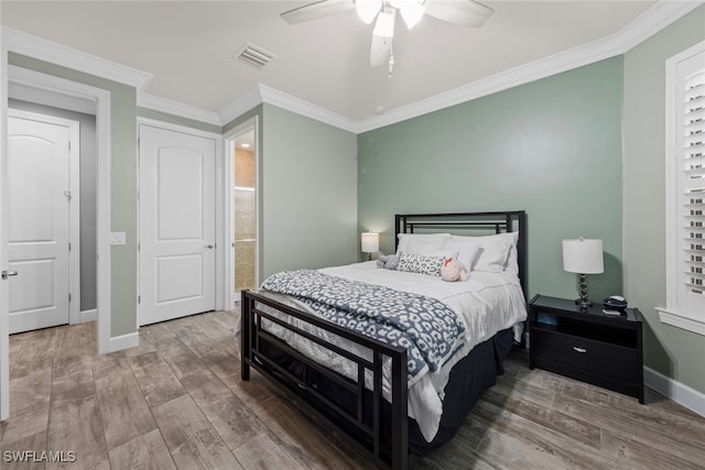 bedroom with ornamental molding, hardwood / wood-style flooring, ceiling fan, and ensuite bath