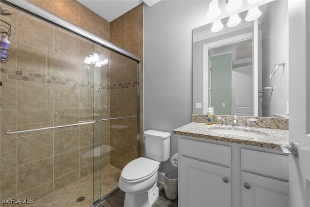 bathroom featuring toilet, vanity, and an enclosed shower