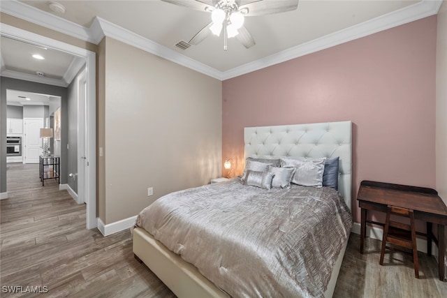 bedroom featuring ceiling fan, wood-type flooring, and ornamental molding