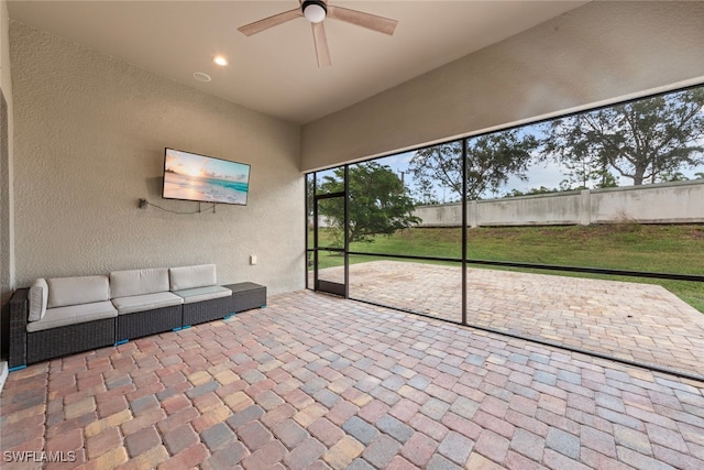 unfurnished sunroom with ceiling fan