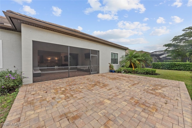 back of property with a patio and a sunroom