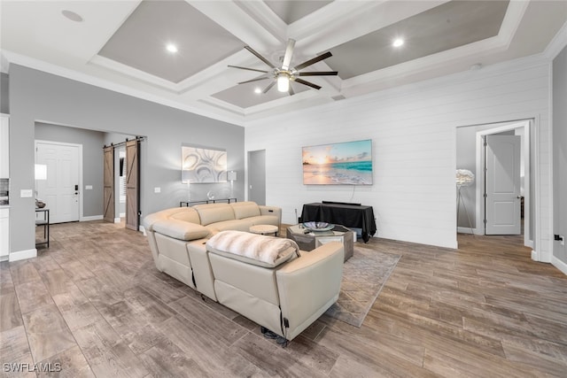 living room with light wood-type flooring, beamed ceiling, a barn door, and coffered ceiling