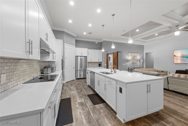 kitchen featuring white cabinetry, hanging light fixtures, an island with sink, and stainless steel appliances