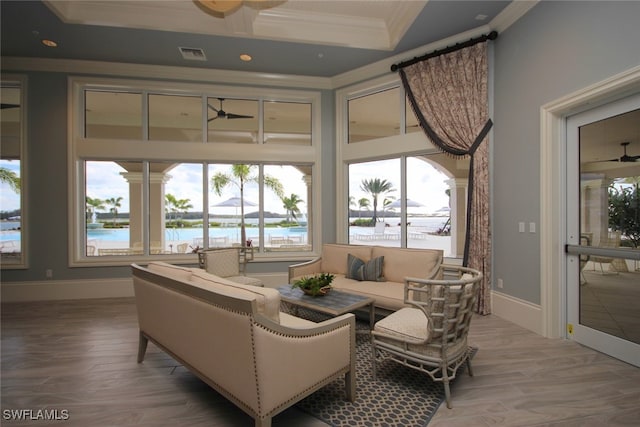 sunroom / solarium featuring a water view and ceiling fan