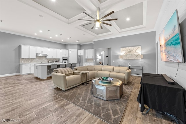 living room featuring dark hardwood / wood-style flooring, ceiling fan, crown molding, and coffered ceiling