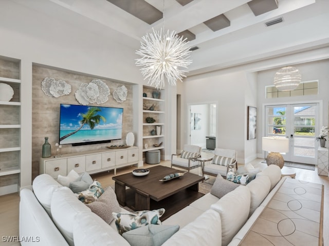 living room featuring french doors, beamed ceiling, built in features, a chandelier, and light hardwood / wood-style floors