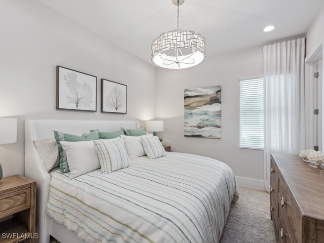 carpeted bedroom featuring a notable chandelier