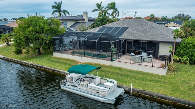 exterior space with a patio, a yard, a water view, and glass enclosure