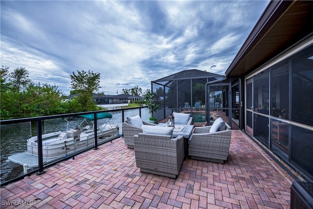 view of patio featuring a water view, an outdoor living space, and a lanai