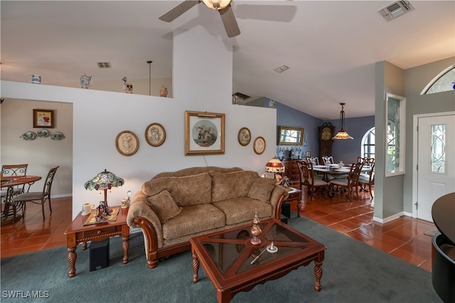 tiled living room with lofted ceiling and ceiling fan