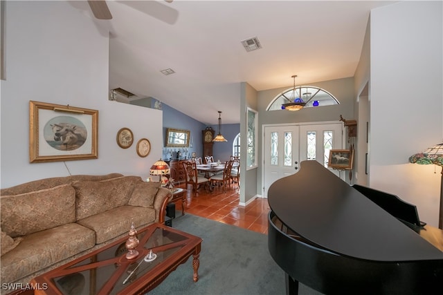 tiled living room with french doors, high vaulted ceiling, and ceiling fan with notable chandelier